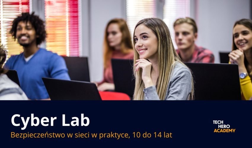 Grupa uczniow z trenerem przy laptopach na zajeciach Cyber Lab
