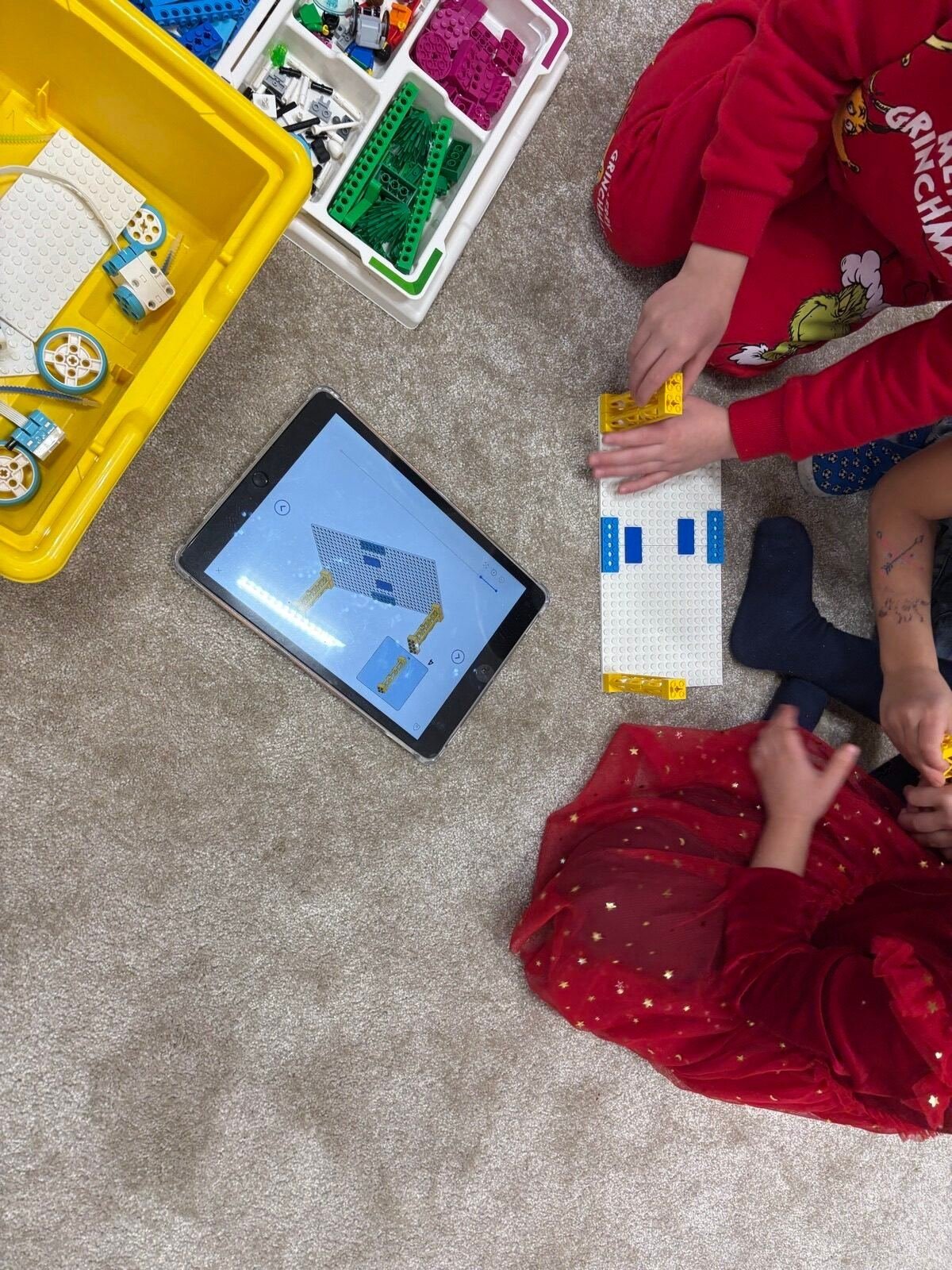 Półkolonie Tech Hero Academy: dwoje dzieci składa model z klocków według instrukcji na tablecie
