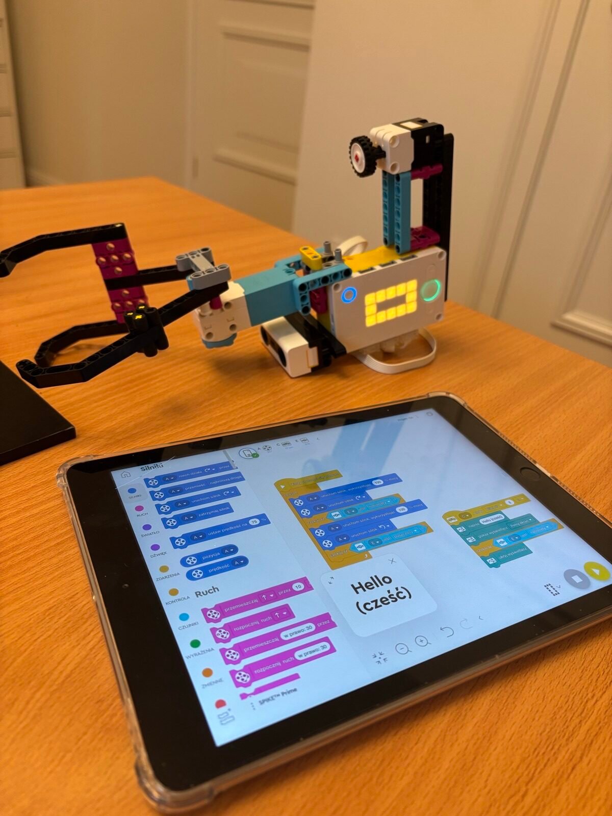 Półkolonie Tech Hero Academy: robot z klocków obok tabletu z programem ułożonym z bloków