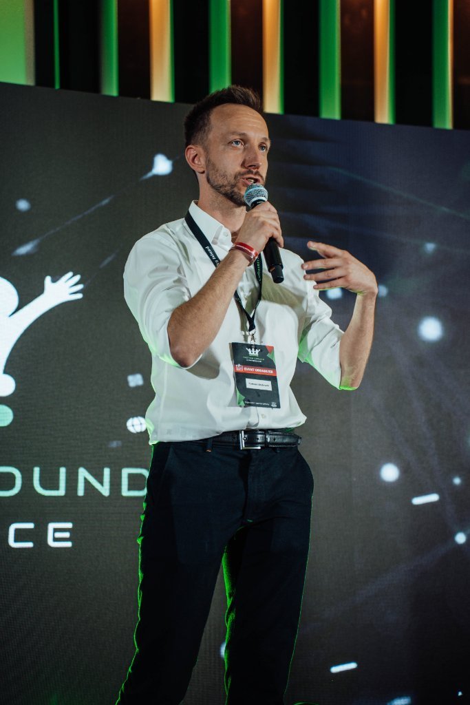 Tomasz Stelmach na scenie Testing Ground Conference, zdjęcie z brand booka Quality Island