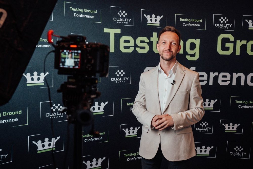 Tomasz Stelmach przed ścianką Testing Ground Conference i Quality Island