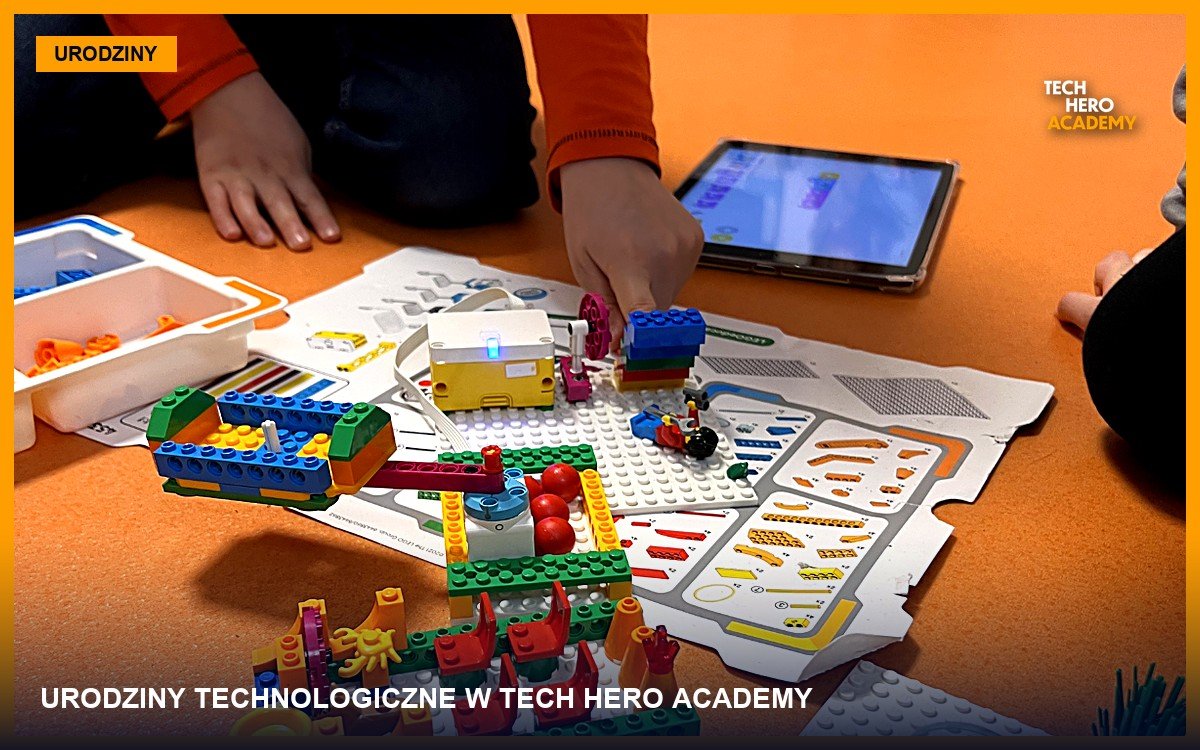 Dzieci na podłodze budują konstrukcje z klocków LEGO i programują je na tablecie podczas urodzin technologicznych w Tech Hero Academy