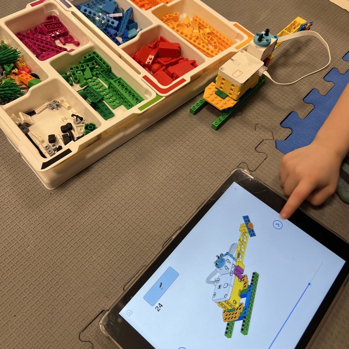 Wyposażenie pracowni komputerowej: pojemniki z zestawami LEGO Education i tablet z programem